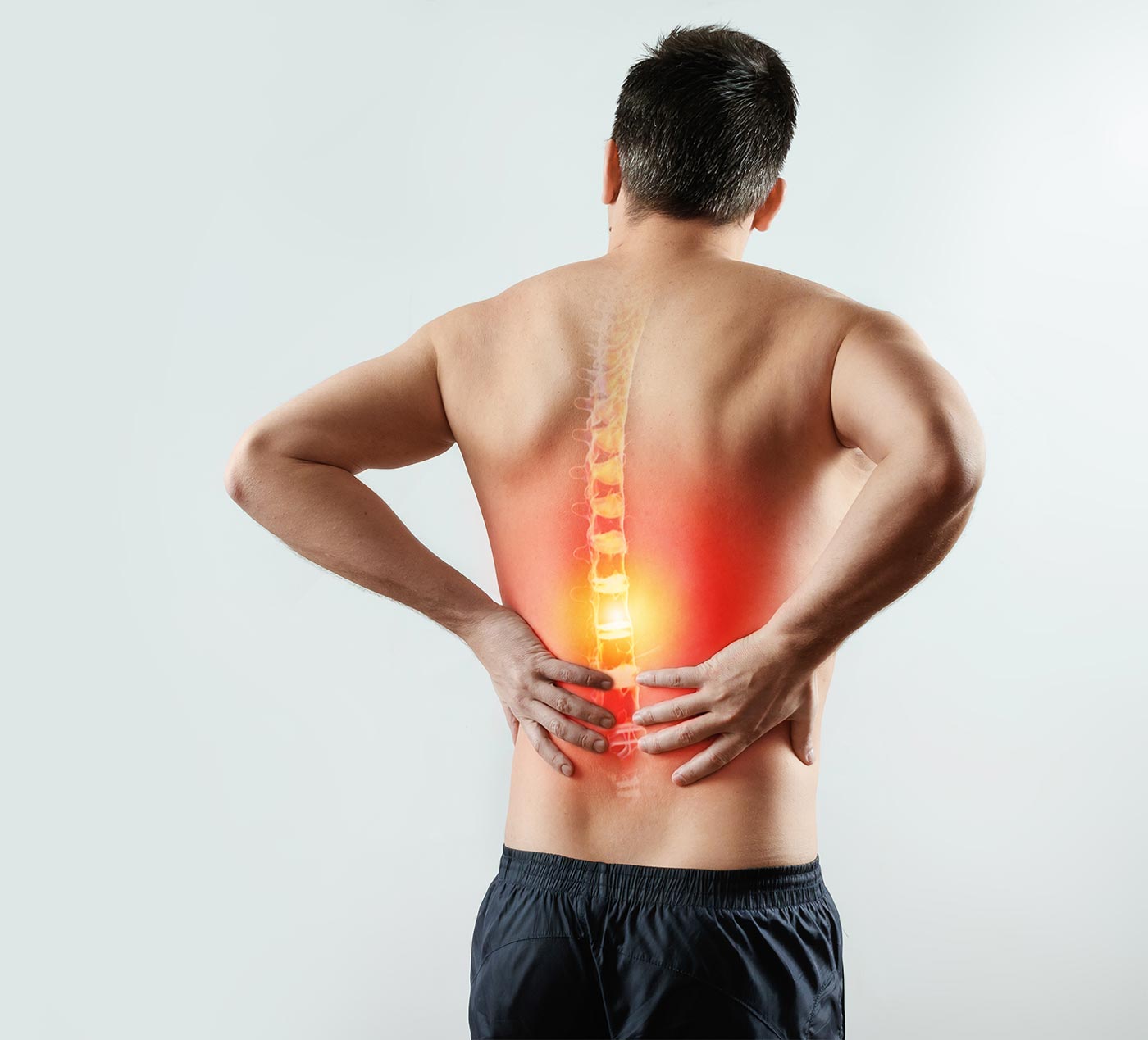 Rear view, the man holds his hands behind his back, pain in the back, pain in the spine, highlighted in red. Light background. The concept of medicine, massage, physiotherapy, health.